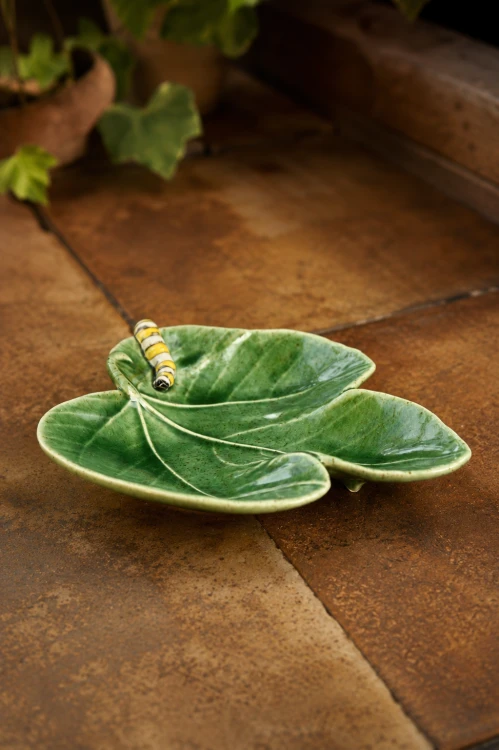 Ceramiczny liść figi z gąsienicą 18 cm na stole.png